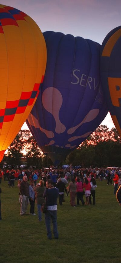 Different coloured balloons about to lift off