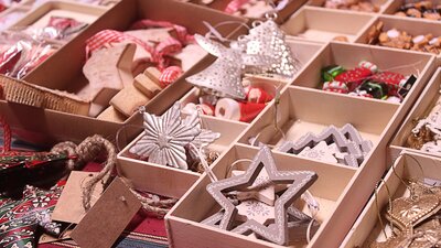 Christmas ornaments in open boxes sitting on a table an a market