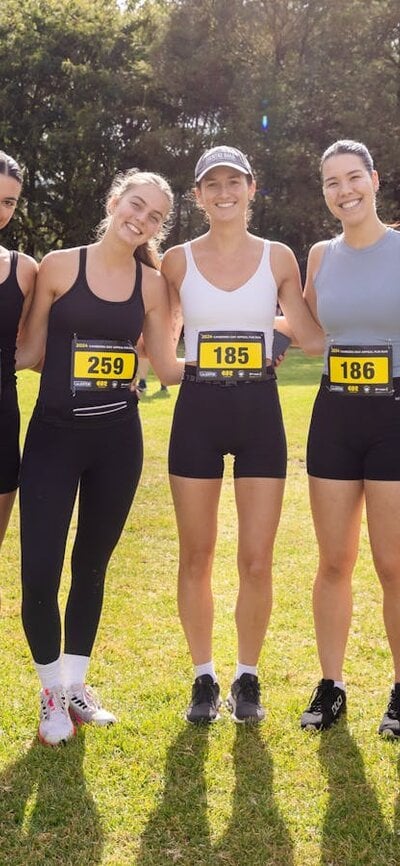 Group of people smiling to the camera, prior to participating in the fun run