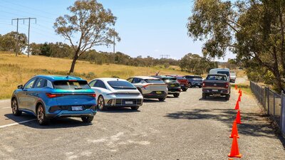 Electric vehicles lined up next to a road, ready to be taken for a test drive.