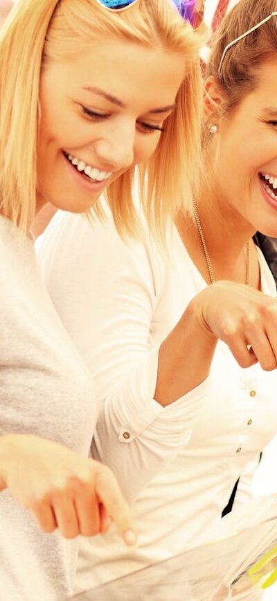 two women and a man smiling at lollies on display at a market stall