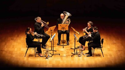 Five brass players performing