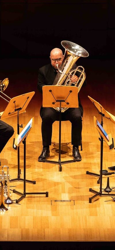 Five brass players performing