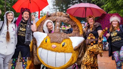 People smiling and posing with Cat Bus kinetic sculpture