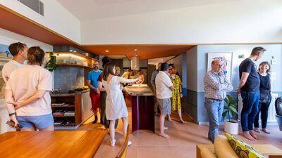 A group of people touring inside a home in the kitchen with bare feet