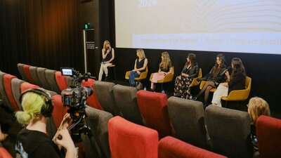 Panel at a previous CSFF screening The image depicts a panel discussion taking place in front of a cinema screen