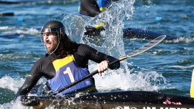 A single player is in the foreground, he is looking back whilst water splashes around him