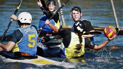 One player in goals has their paddle up, whilst the opposition is ready to shoot the ball