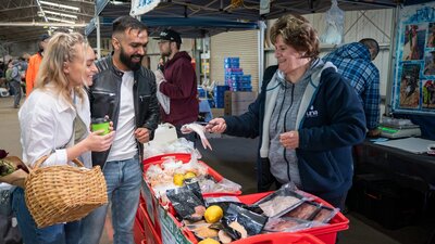 shoppers selecting fresh seafood from local farmers market in Canberra