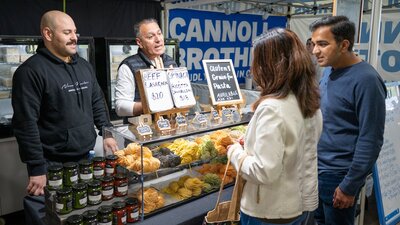 shoppers selecting fresh pasta from local farmers market in Canberra