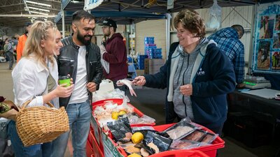 shoppers selecting fresh seafood from local farmers market in Canberra