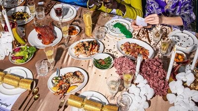 Platters of food and drink glasses spread out on beige table