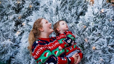 Snowy Christmas trees Women with baby admiring white Christmas trees