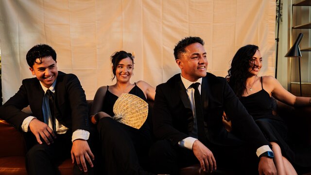 The Amosa Family The Amosa family sitting and smiling dressed in formal wear and posed for a photo shoot