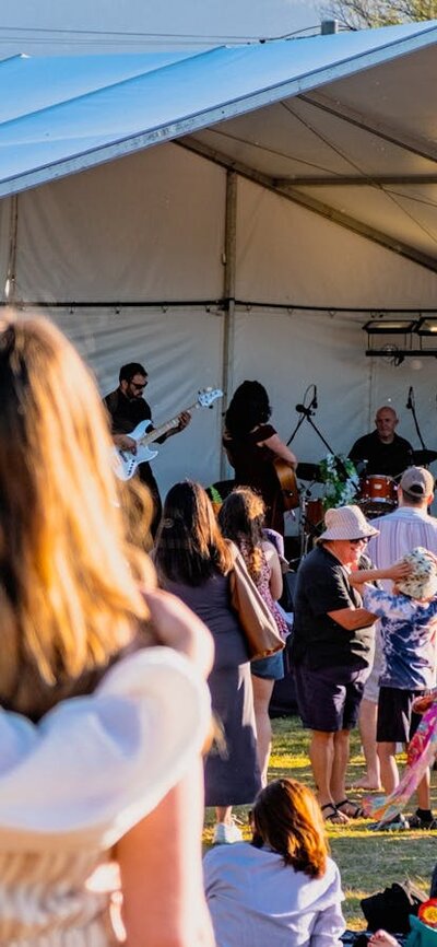 Two women watching Kirrah Amosa perform at Lanyon Homestead