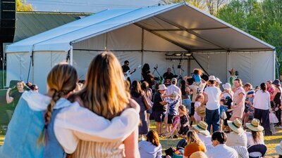 Two women watching Kirrah Amosa perform at Lanyon Homestead