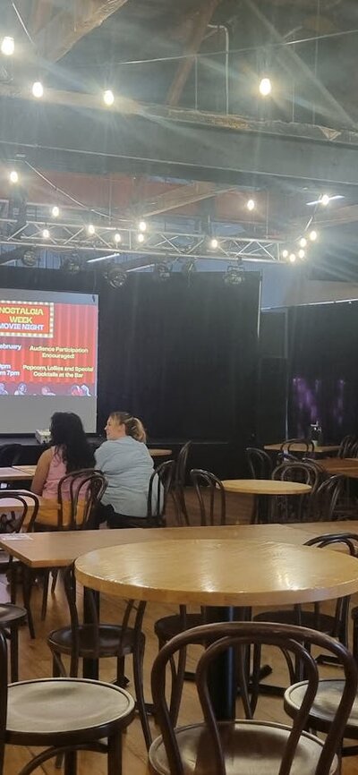 Tables and chairs with the screen up on the stage