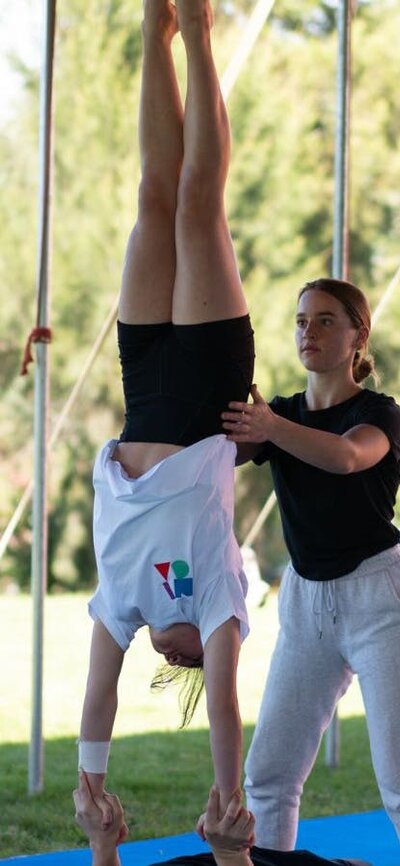 Young acrobats practie a hand-to-hand maneouvre vre