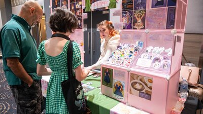 2 people looking at a pink stall