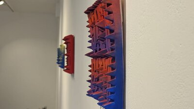 Concrete Captions: Texting Rights by Kirsty Collins Red and blue square ceramic artwork with textured spikes.