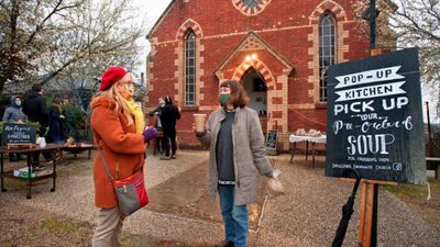 People gathering outside a red brick church.