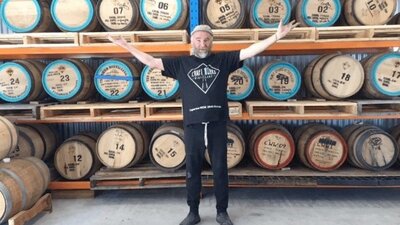 Craft Works head distiller in front of casks