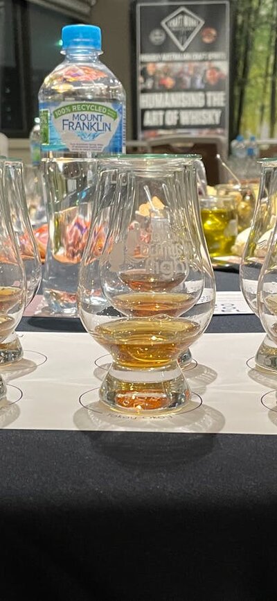 Whisky tasting place setting with filled glasses with Craft Works distiller in background