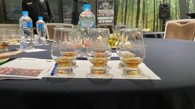 Whisky tasting place setting with filled glasses with Craft Works distiller in background