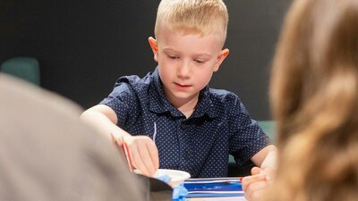 A child doing craft at a table