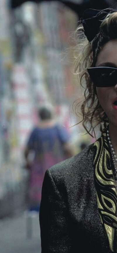 Desperately Seeking Susan, Fri 17 Apr 8:00 PM Woman walking towards man wearing 1980s style clothing, sunnies and big hair bow