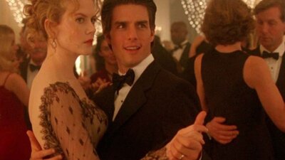 Still from Eyes Wide Shut showing a couple dancing and looking to the side