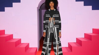 Ji Won Choi x Adidas. Courtesy Adidas Lady modelling outfit behind pink stairs and purple background