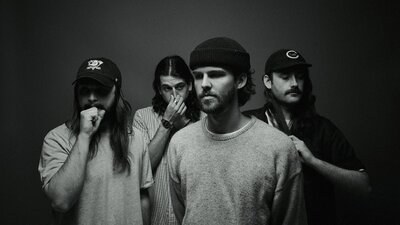 The four members of Dear Seattle facing in different directions away from the camera posing.