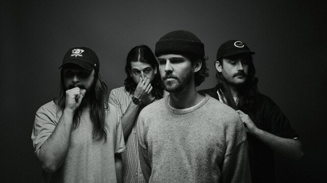The four members of Dear Seattle facing in different directions away from the camera posing.
