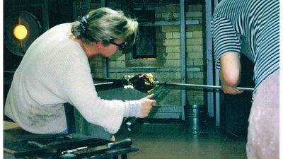 Glass artist blowing glass