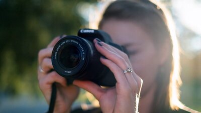 Photograph of a woman taking a photograph with a digital camera
