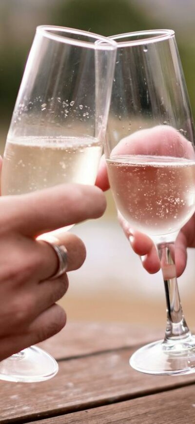 Two people clinking champagne glasses at Lanyon Homestead