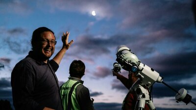 Man next to telescope describes something about night sky at Lanyon Homestead