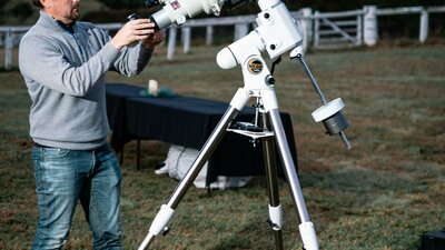 Man adjusts telescope at Lanyon Homestead