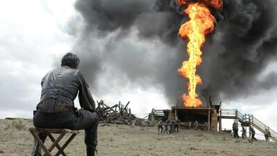 Man seated watching a firey explosion