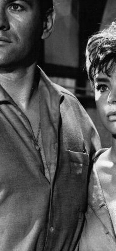Black and white image of woman and man standing together looking forlorn past the camera