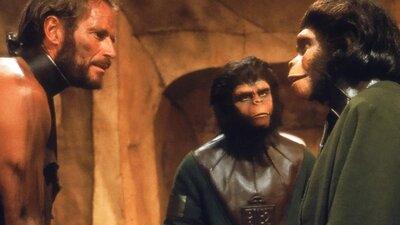 Double Feature: Barbarella + Planet of the Apes (35mm), 24 July, 2026 Two ape looking figures facing a man wearing a metal collar