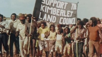 Protest with group of people holding sign saying support to Kimberley land council
