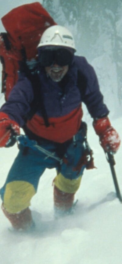 Harder than Everest (1987) A figure in snow gear with snow poles, walking up a snowy mountain towards camera