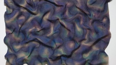 Purple, Blue, Green and Yellow fabric laid out in a wrinkled shape
