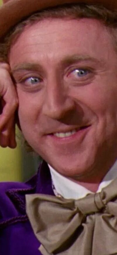 Man with top hat resting on his hand smiling