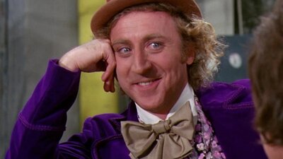 Man with top hat resting on his hand smiling