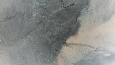 A mix of grey, beige and white paint melding in an abstract pattern