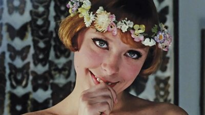 Young woman with a bob haircut and flower crown with thumb in mouth