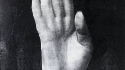 disembodied hand show the palm against a black background